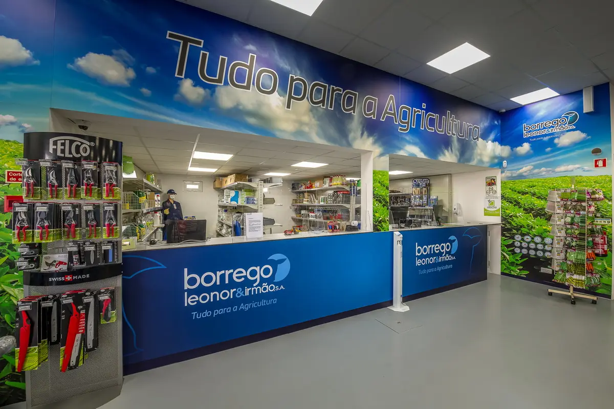 Interior da loja da Zona Industrial de Almeirim, com balcão de atendimento e prateleiras de produtos agrícolas.